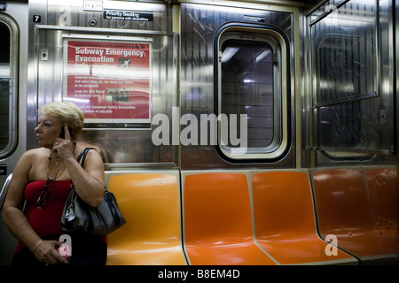 Femme parlant au téléphone dans un train de métro de New York Banque D'Images
