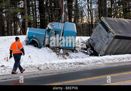 Semi truck dans les fossés dans la neige avec un homme à la recherche sur Banque D'Images