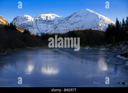 Un couvert de neige Bidean nam Bian et congelé Lochan en hiver, Lochaber, Glen Coe, en Écosse. Banque D'Images