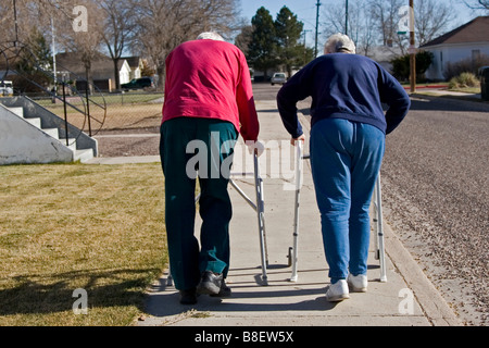 Deux personnes âgées personnes âgées à pied à l'aide de marcheurs, l'un des quatre en série Banque D'Images