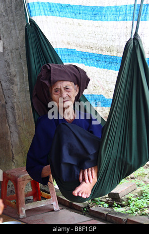 Vieille femme vietnamienne dans un hamac en regardant la caméra. My Tho. Delta du Mekong, Vietnam Banque D'Images