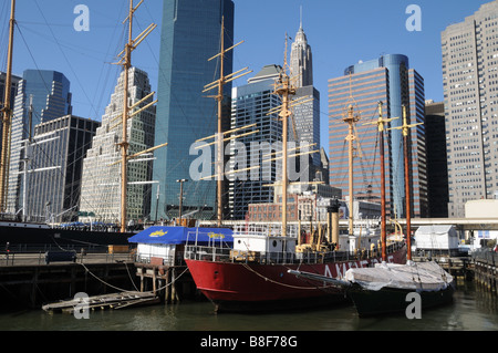 Sur l'East River dans le Lower Manhattan, les navires historiques sont à quai dans le port maritime de South Street sur un fond de gratte-ciel. Banque D'Images