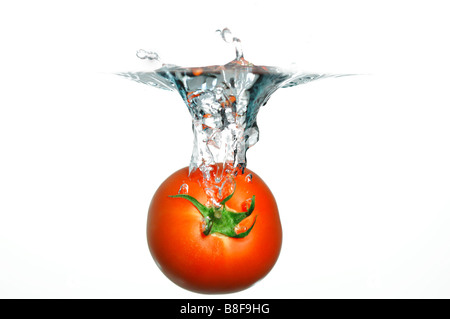 Tomate rouge fraîche tomber à l'eau Banque D'Images