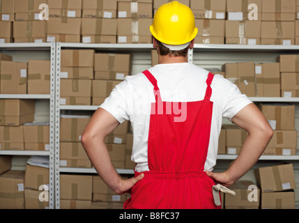 Offres debout devant une étagère avec beaucoup de marchandises en c Banque D'Images