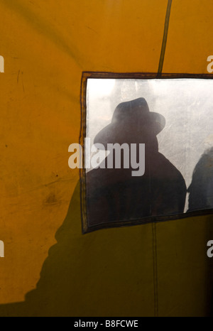Silhouette d'un homme portant un chapeau à large hat vu à travers l'écran jaune Banque D'Images