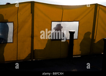 Silhouette d'un homme portant un chapeau à large hat vu à travers l'écran jaune Banque D'Images