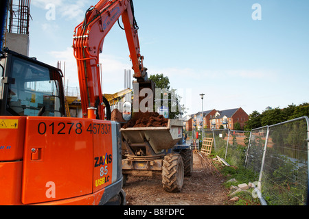 La construction de nouveaux appartements à taunton Cricket Club. Jcb le chargement d'un tombereau de terre Banque D'Images