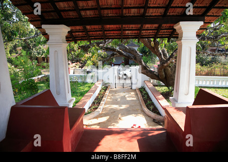 Vue du coin sur véranda de chemin d'accès à porte d'entrée dans le mur blanc du jardin de l'Inde Banque D'Images