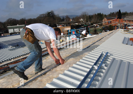 Les entrepreneurs isolation supplémentaire sur le toit d'une unité industrielle à Bovey Tracey Devon Banque D'Images