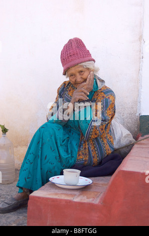 Une vieille femme de boire du café / chocolat sur le perron de sa maison, dans la ville de Tibasosa, Colombie Banque D'Images