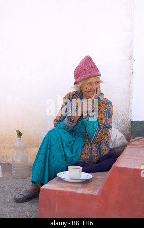 Une vieille femme de boire du café / chocolat sur le perron de sa maison, dans la ville de Tibasosa, Colombie Banque D'Images