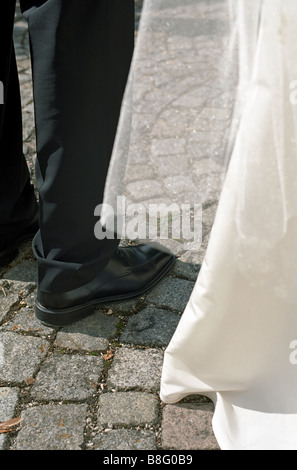 Les jambes de l'époux à côté de la de la Mariée sur pavés - Section - Plaza - Mariage Banque D'Images