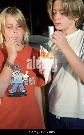 Deux garçons eating Chips hors d'un peu The Paperbag - Plats à emporter - Nutrition - Jeunesse Banque D'Images