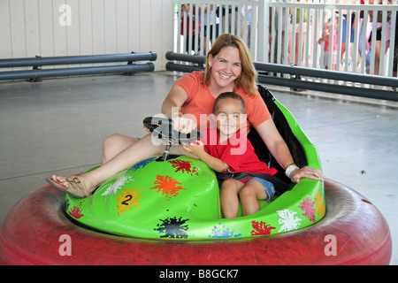 Mère et fils sur dodgem voiture à fairground Banque D'Images