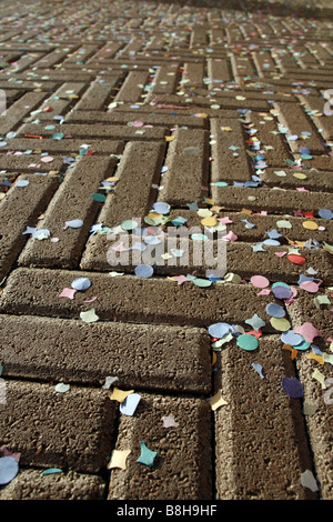 Beaucoup de confettis multicolores et de guirlandes sur route pavée à Sun Banque D'Images