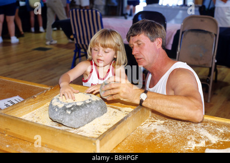 Père et fille à l'aide d'un mortier et pilon dans le musée des Indiens d'Amérique du Nord au Crazy Horse Memorial dans le Dakota du Sud Banque D'Images