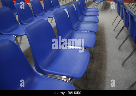 Des rangées de chaises en plastique bleu vide dans la salle de conférence Banque D'Images