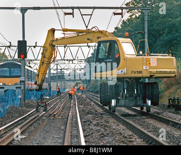 Le travail au sein d'une machine Rail-route clairement marquée, le blocus ferroviaire limite définie par blue clôture avec titres live à l'extérieur. Banque D'Images