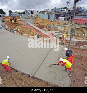 Le transfert par les entrepreneurs béton liquide pompe à béton armé d'acier de construction de la route d'accès à l'usine de transformation de déchets en énergie. Banque D'Images