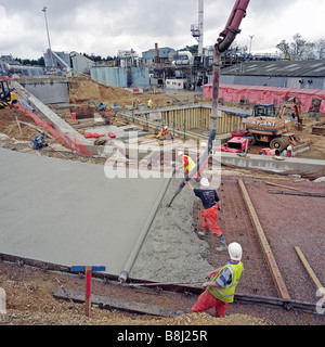 Le transfert par les entrepreneurs béton liquide pompe à béton armé d'acier de construction de la route d'accès à l'usine de transformation de déchets en énergie. Banque D'Images