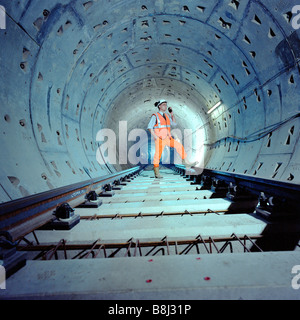 Engineer inspecting trackwork nouvellement posées dans un Jubilee Line Extension tunnel sur le réseau de métro de Londres. Banque D'Images