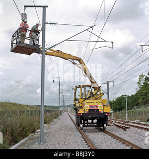 Entrepreneurs en construction à l'aide de la plate-forme rail-route les fils d'alimentation de l'installation sur le toit de 25KV système caternary sur le Channel Tunnel Rail Link. Banque D'Images