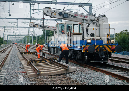 Lits jumeaux automoteur-jib grue ferroviaire se prépare à soulever le panneau voie redondante lors d'un programme de remplacement des voies. Banque D'Images