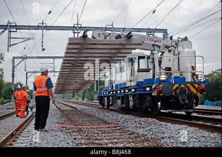 Deux automotrices ferroviaires lourds de levage de la grue à flèche de la section panneau voie redondante lors d'un programme de remplacement des voies. Banque D'Images