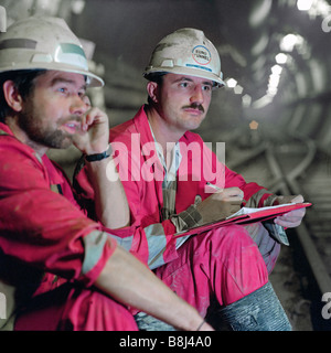 Les ingénieurs de contrôle Eurotunnel examiner et de discuter des travaux en cours dans le tunnel de service sur le projet du Tunnel sous la Manche. Banque D'Images