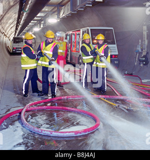 Les pompiers à l'essai l'équipement incendie dans le Tunnel sous la Manche tunnel de service - d'émulsifiant dans l'eau produit de la mousse. Banque D'Images