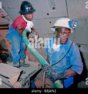 Tunnel en béton de coulis de travailleurs de soutien dans les segments de la paroi du tunnel de livraison sur l'historique 30 ans Lesotho Highlands Water Project Banque D'Images