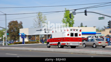 Excès d'ambulance passé le trafic sur une rue Américaine la position d'une urgence Banque D'Images