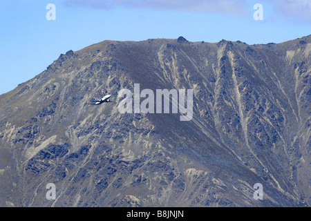 Un avion décolle de l'aéroport de Queenstown, avec les Remarkables en arrière-plan, Nouvelle-Zélande Banque D'Images