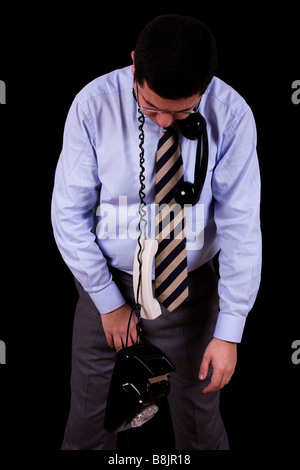 Businessman étrangler avec son téléphone isolated on black Banque D'Images