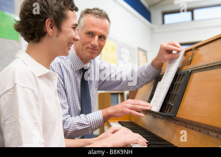 L'apprentissage des élèves masculins avec piano teacher in classroom Banque D'Images