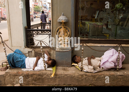 Inde Madurai Tamil Nadu deux hommes dormant dans la petite rue à côté de temple hindou Sri Ganesh Banque D'Images