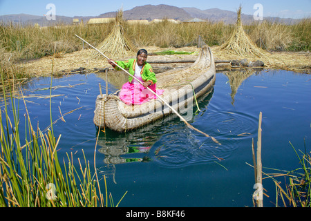 Les Indiens Uros femme Jiménez-montealegre tortora reed bateau avec les cobayes (cuy) île en arrière-plan, le Lac Titicaca, Pérou Banque D'Images