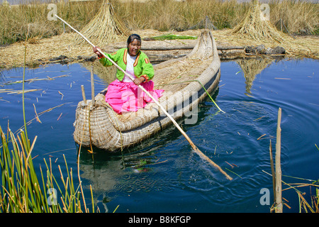 Les Indiens Uros femme Jiménez-montealegre tortora reed bateau avec les cobayes (cuy) île en arrière-plan, le Lac Titicaca, Pérou Banque D'Images