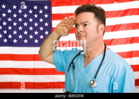 Patriotic American doctor giving un salut au drapeau photographié devant un drapeau pas une image composite Banque D'Images