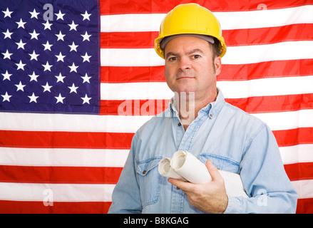 Travailleur de la construction avec les bleus en face d'un drapeau américain photographié devant le drapeau non une image composite Banque D'Images