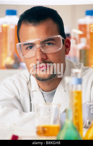 Male Hispanic Technicien de laboratoire de recherche scientifique en environnement de laboratoire, vêtus de blanc et labcoat lunettes de sécurité. Banque D'Images