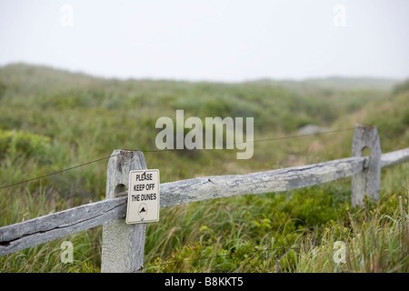 Un écriteau "ne pas marcher sur les dunes, sur un temps battu clôture sur l'image. Banque D'Images