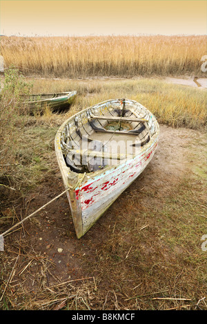 Vieux bateaux inutilisés se trouvant à marée basse, les marais salants de la côte nord du comté de Norfolk [Royaume-Uni]. Banque D'Images