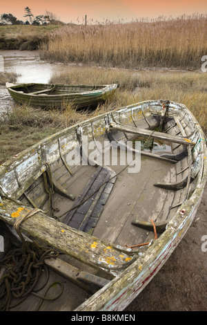 Vieux bateaux inutilisés se trouvant à marée basse, les marais salants de la côte nord du comté de Norfolk [Royaume-Uni]. Banque D'Images