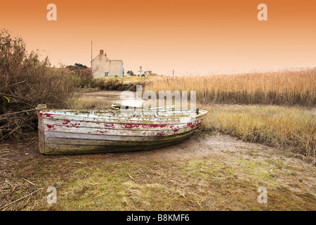 Vieux bateaux inutilisés se trouvant à marée basse, les marais salants de la côte nord du comté de Norfolk [Royaume-Uni]. Banque D'Images