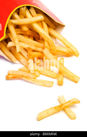 Fast food malsaine. Frites tombant de carton fort incliné, deux pièces qui ressemble à une croix, fond blanc Banque D'Images