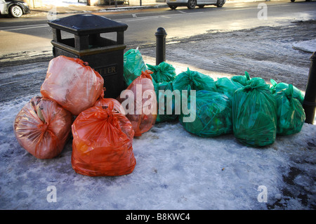 Sacs empilés sur un sentier couvert de neige à côté d'un casier dans Wimbledon Village, à l'ouest de Londres, Royaume-Uni. Banque D'Images