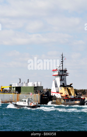 Tugboat pushing une "double coque" par barge de carburant les eaux agitées de la 'Cape Cod Canal' avec 'bateau' aux côtés de pilotes. Banque D'Images