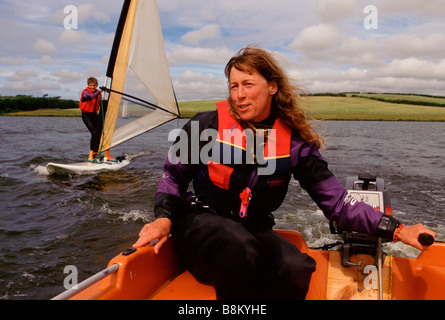 Cornwall UK un moniteur de planche à voile et son élève pratiques sur un lac Banque D'Images