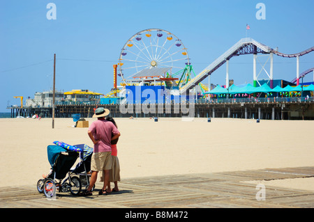 Une famille en face de la jetée et du Pacific Park, Santa Monica CA Banque D'Images